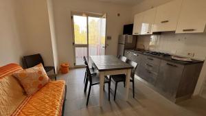 a kitchen and dining room with a table and a couch at Residence Jolly in Peschici