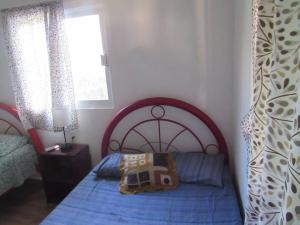 a bedroom with a bed with a blue comforter at surf la bamba in Dolores Miramar