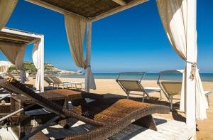 a group of chairs and tables on a beach at Residence Jolly in Peschici