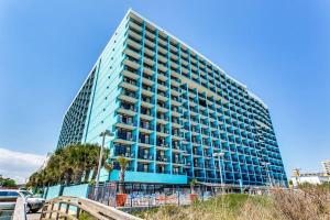 a tall blue building with balconies on a beach at WINTER RATES! Impeccable Oceanfront Suite, Top Floor! L1543 in Myrtle Beach