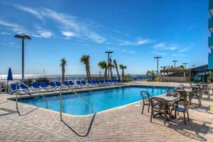 a swimming pool with chairs and a table and a beach at WINTER RATES! Impeccable Oceanfront Suite, Top Floor! L1543 in Myrtle Beach