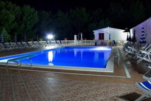 a large swimming pool at night with chairs around it at Residence Jolly in Peschici