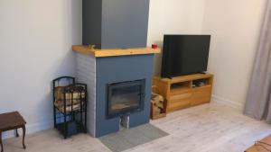 Una sala de estar con chimenea y televisión. en Teraz Karpacz, en Karpacz