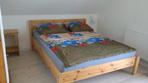 Una cama con marco de madera con flores. en Teraz Karpacz, en Karpacz