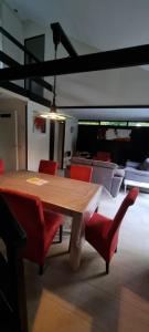 a wooden table with red chairs in a room at Bungalow het Zuiderveld in Geesbrug