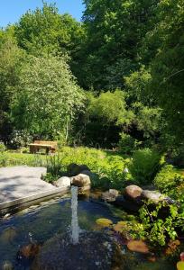a pond with a fountain in the middle of a park at Schöne 120-qm-Ferienwohnung - Sonnenterrasse - Stadtgrenze Lübeck in Stockelsdorf