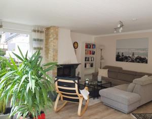 a living room with a couch and a chair at Schöne 120-qm-Ferienwohnung - Sonnenterrasse - Stadtgrenze Lübeck in Stockelsdorf