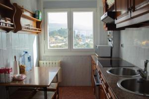 une petite cuisine avec un évier et une fenêtre dans l'établissement Precioso piso con vistas a las Islas Cíes, à Baiona