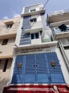 a building with blue doors on the side of it at Buddhar Illam in Palni