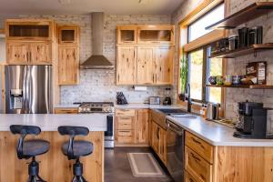 a kitchen with wooden cabinets and bar stools at Inlet View Home in Homer
