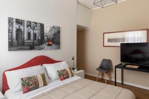 a bedroom with a white bed and a tv at Volta Accomodation in Milan