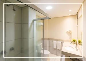 a bathroom with a shower and a toilet and a sink at Hotel Vila Rica Campinas in Campinas