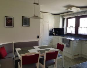 a kitchen with a table and chairs in a kitchen at Schöne 120-qm-Ferienwohnung - Sonnenterrasse - Stadtgrenze Lübeck in Stockelsdorf