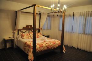 ein Schlafzimmer mit einem Himmelbett und einem Kronleuchter in der Unterkunft Villa El Valle in Tarajalejo + 15 Fotos