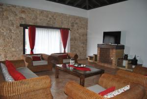 ein Wohnzimmer mit Sofas und einem Flachbildfernseher in der Unterkunft Villa El Valle in Tarajalejo