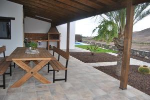 ein Holztisch und Stühle auf einer Terrasse in der Unterkunft Villa El Valle in Tarajalejo