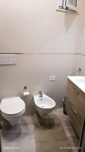 a white bathroom with a toilet and a sink at Grotthouse in Andria +13 photos