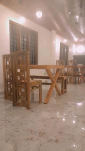 un tavolo e delle sedie di legno in una stanza di ANGEL homestay kochi a Cochin