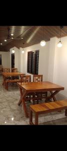 un gruppo di tavoli e panche in legno in una stanza di ANGEL homestay kochi a Cochin