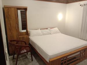 una piccola camera da letto con un letto e una sedia di ANGEL homestay kochi a Cochin