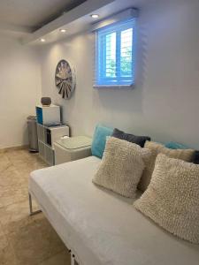 een woonkamer met een bank en een klok aan de muur bij Le Cœur De Simpson Bay in Simpson Bay