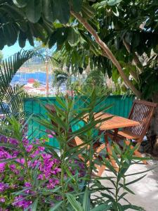een houten tafel en stoel in een tuin met bloemen bij Le Cœur De Simpson Bay in Simpson Bay