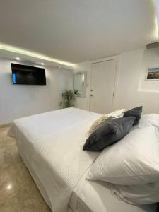 een slaapkamer met een wit bed met kussens erop bij Le Cœur De Simpson Bay in Simpson Bay