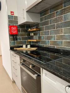 a kitchen with black and white tiles on the wall at Cosy Apartment Queluz By Gt House in Queluz +14 photos