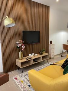 a living room with a television and a yellow couch at Cosy Apartment Queluz By Gt House in Queluz