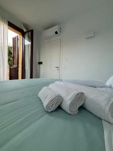 a bed with two towels sitting on top of it at Luminoso alloggio sul mare in Cattolica