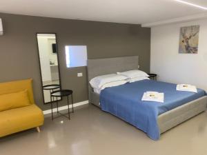 una camera da letto con un letto e una sedia gialla di B&B Suite Cutelli a Catania
