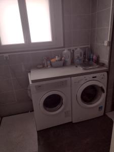 a laundry room with a washing machine and a window at Le Brossolette 3 in Saint-Denis +4 photos