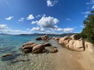 a group of rocks in the water on a beach at Casa Stella Residence Ea Bianca Baja Sardinia in Baja Sardinia