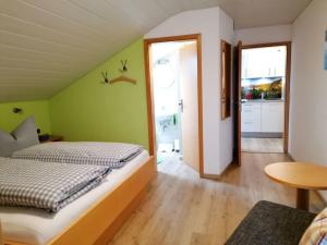 a bedroom with green walls and a bed and a table at Ferienhof Hefele Ferienwohnung Tegelberg mit KönigsCard in Hopferau