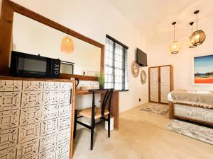 a room with a desk with a television and a bed at The Lux Guesthouse in Kroonstad