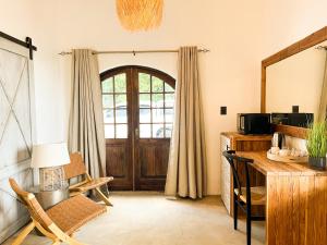 a room with a door and a chair and a table at The Lux Guesthouse in Kroonstad