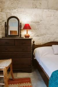 a bedroom with a bed and a dresser with a mirror at Ariadni Cottage in Vasa