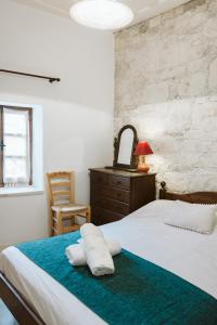 a bedroom with a bed and a dresser and a chair at Ariadni Cottage in Vasa