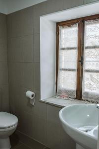 a bathroom with a sink and a toilet and a window at Ariadni Cottage in Vasa +37 photos