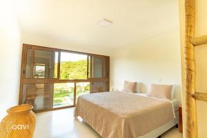una camera da letto con un letto e una grande finestra di Casa Mar no Pipa Natureza by QAVI a Pipa