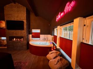 a large bathroom with a tub and a fireplace at Wellness Tuin - Boudoir Suite - Ultieme Partner Beleving met Jacuzzi en Openhaard en privé Sauna in Romantische stijl in Horst