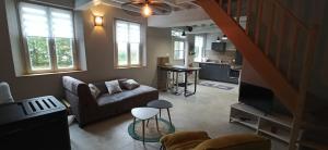 a living room with a couch and a tv in it at La Clé des champs in Luchy