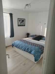a bedroom with a bed with a blue comforter at Le Watt'else in Watten