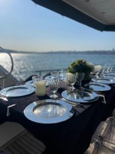 ein langer Tisch mit Tellern und Weingläsern auf einem Boot in der Unterkunft Luxury Yachts Istanbul in Istanbul + 4 Fotos