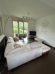 a living room with a white couch in a room at Gîte le Beauchamp in Les Hautes-Rivières