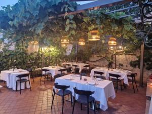 a restaurant with white tables and chairs and vines at La Corte dei Filangieri in Candida