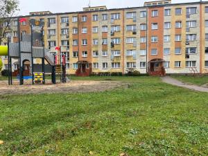 un parco giochi vuoto di fronte a un edificio di Mieszkanko a Koszalin