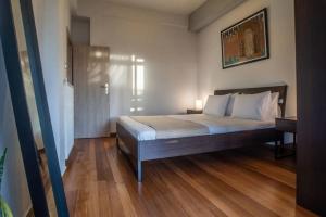 a bedroom with a bed and a wooden floor at The Condo Spacious terrace Acropolis Views in Athens