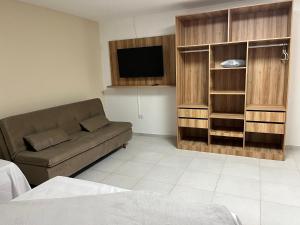 a living room with a couch and a flat screen tv at Tamandaré Divers Resort in Tamandaré