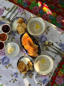a table with plates of food and bowls of soup at Дом 14 in Osh